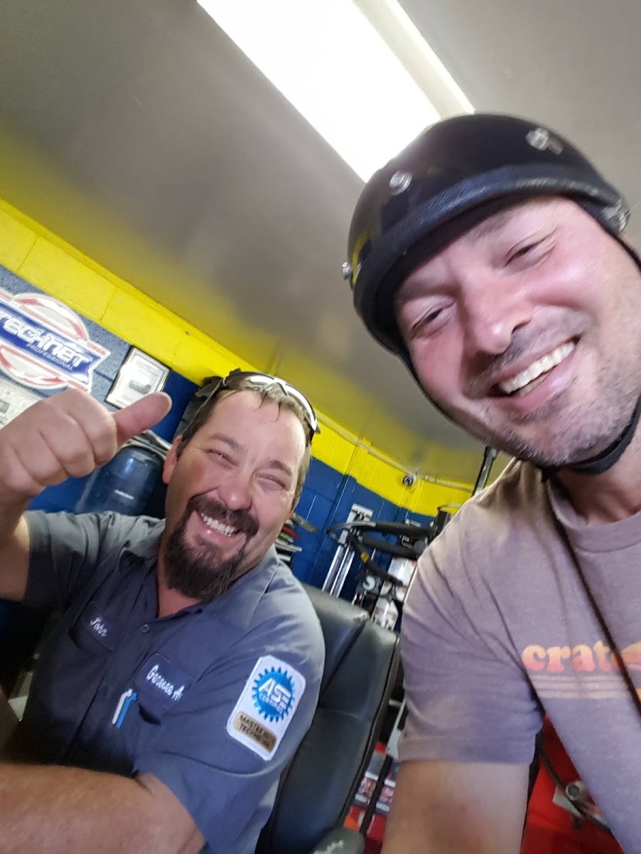 Smiling mechanic and customer snapping a selfie in the shop